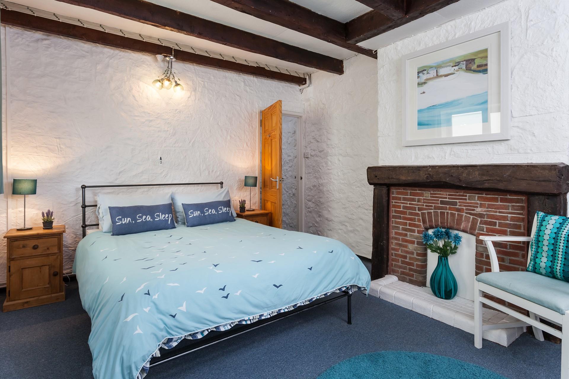 Bedroom 1 has a spacious double bed and is decorated with seaside blue tones.