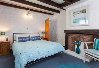 Bedroom 1 has a spacious double bed and is decorated with seaside blue tones.