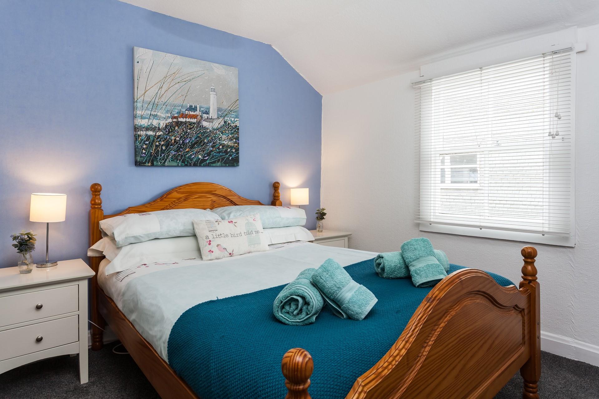 Bedroom 1 boasts coastal blue tones and Cornish artwork.