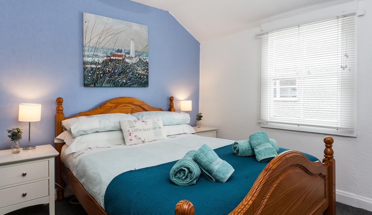 Bedroom 1 boasts coastal blue tones and Cornish artwork.