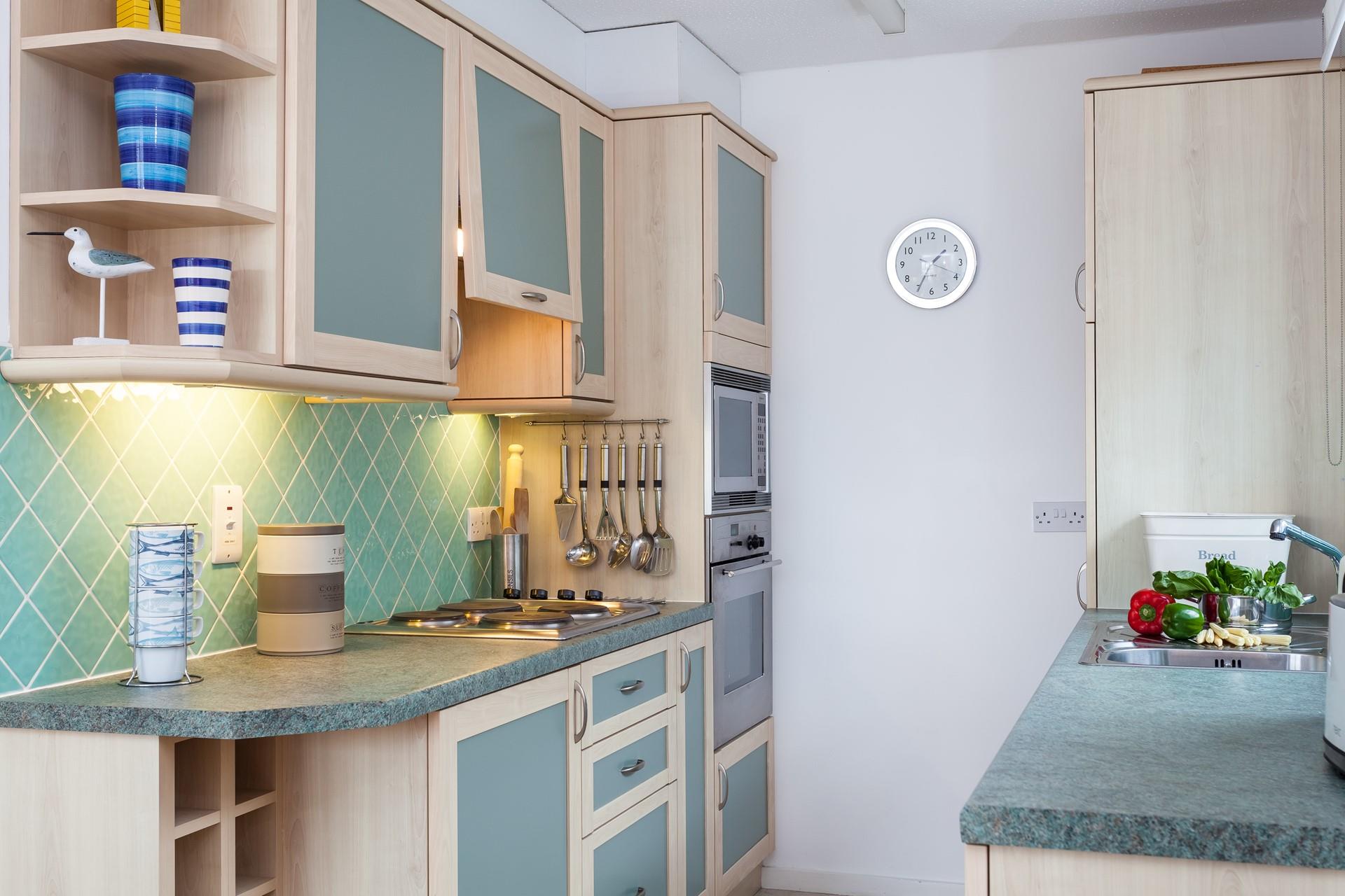 The kitchen has a unique colour scheme that is ideal for a seaside holiday.