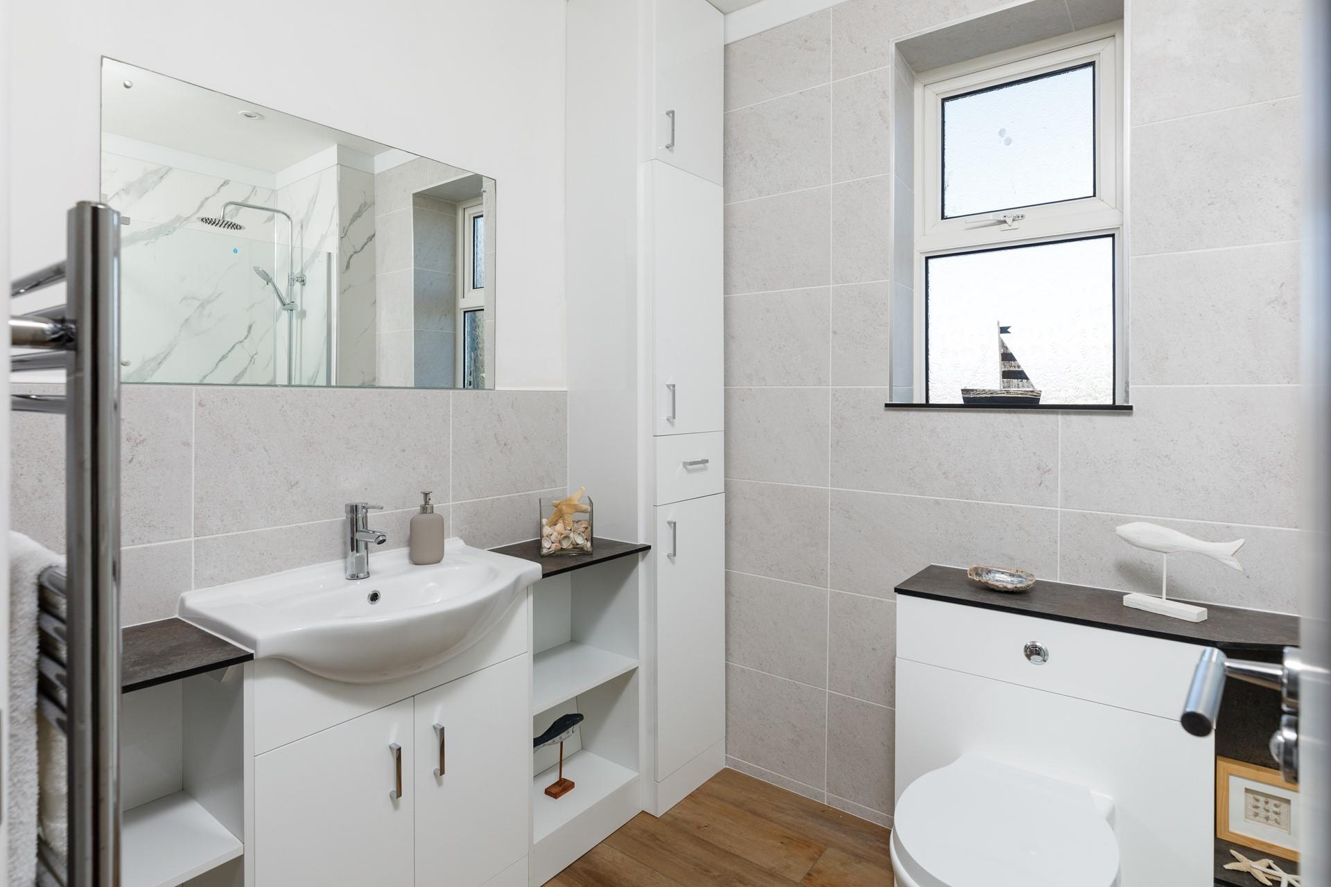 The family bathroom has plenty of storage and a warming towel rail.