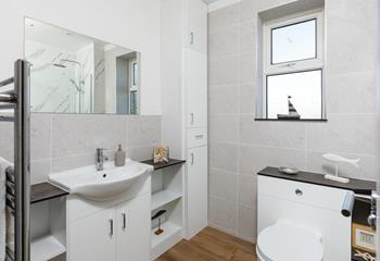 The family bathroom has plenty of storage and a warming towel rail.