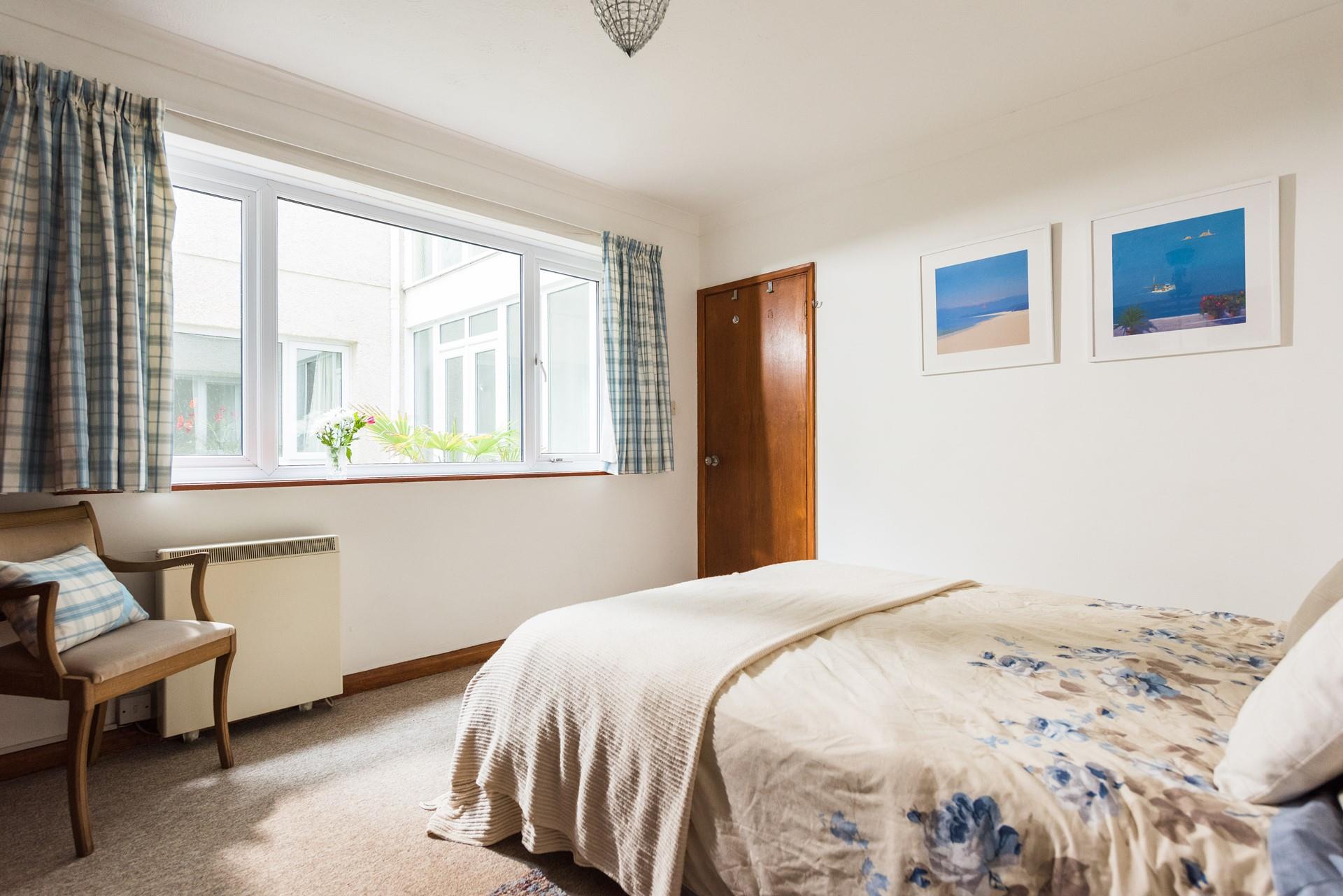 Light and spacious, the main bedroom has a king size bed and large windows. 