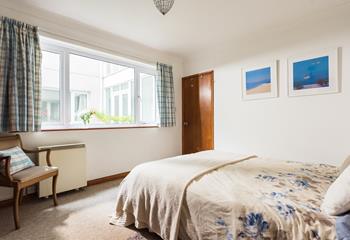 Light and spacious, the main bedroom has a king size bed and large windows. 