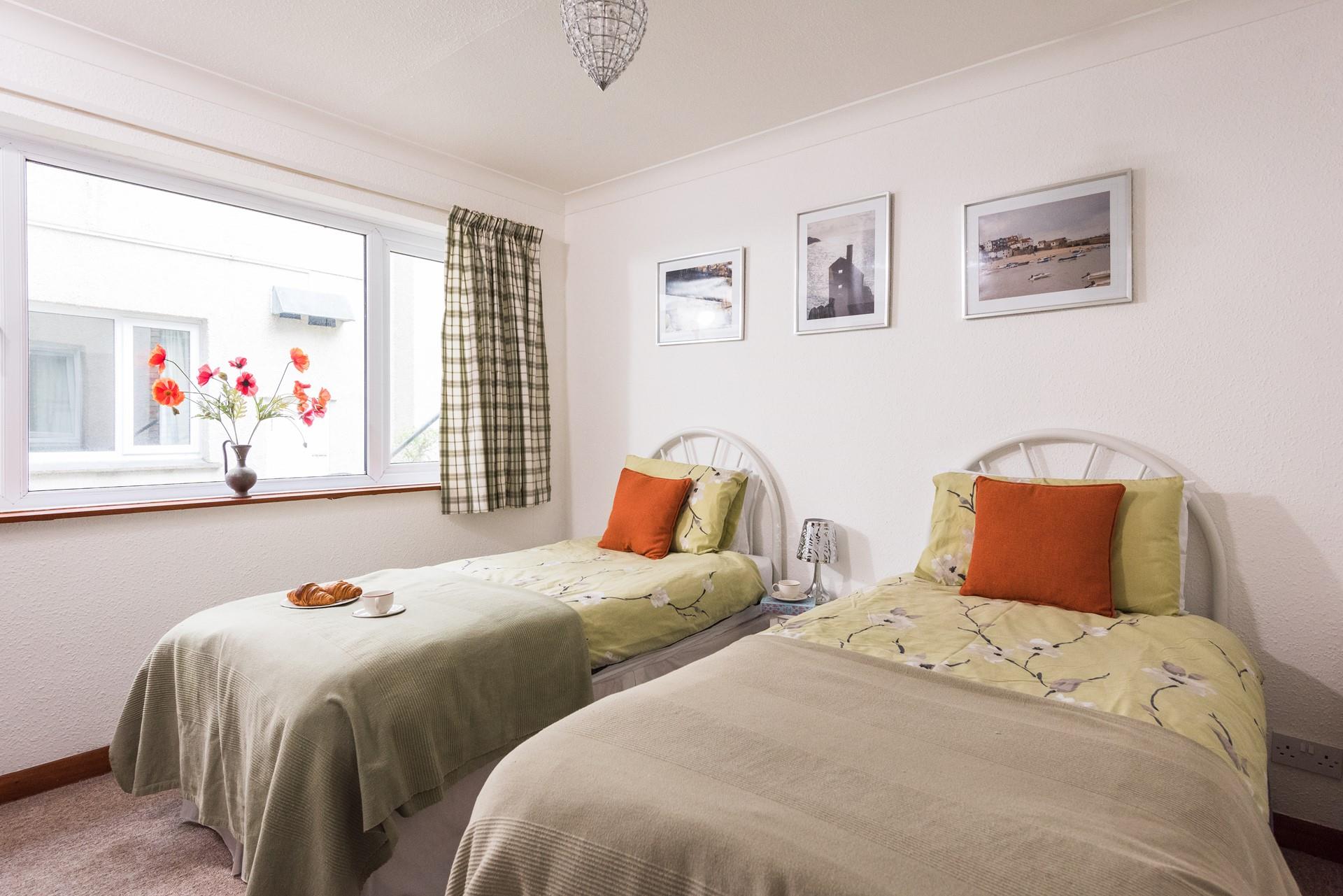 Neutral tones create a relaxing vibe in the twin bedroom. 