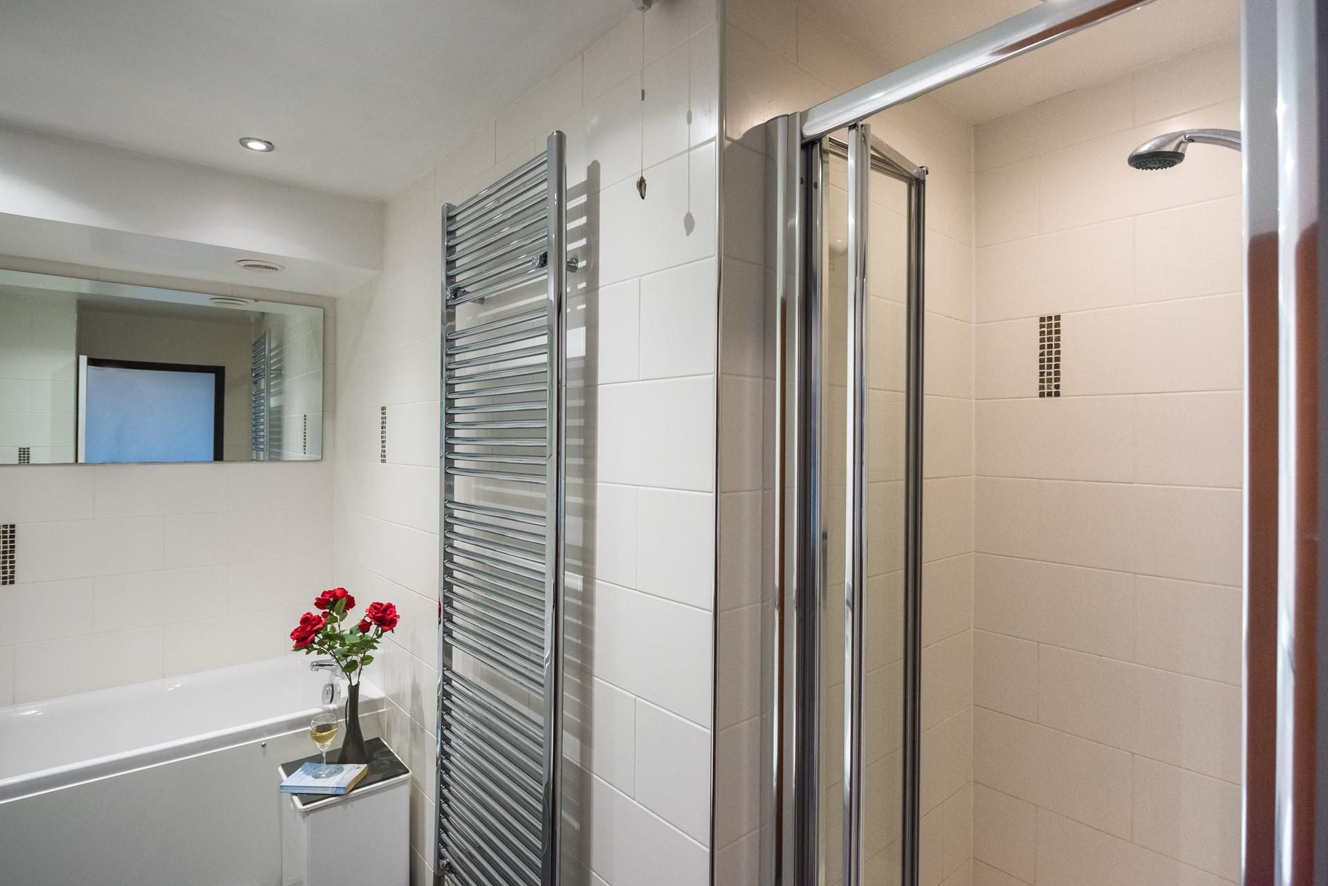 The large family bathroom features a separate bath and an enclosed shower. 