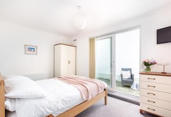 Bedroom 1 is spacious with a patio door leading to the private rear courtyard.