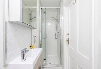 The en suite features an enclosed shower and benefits from a heated towel rail. 