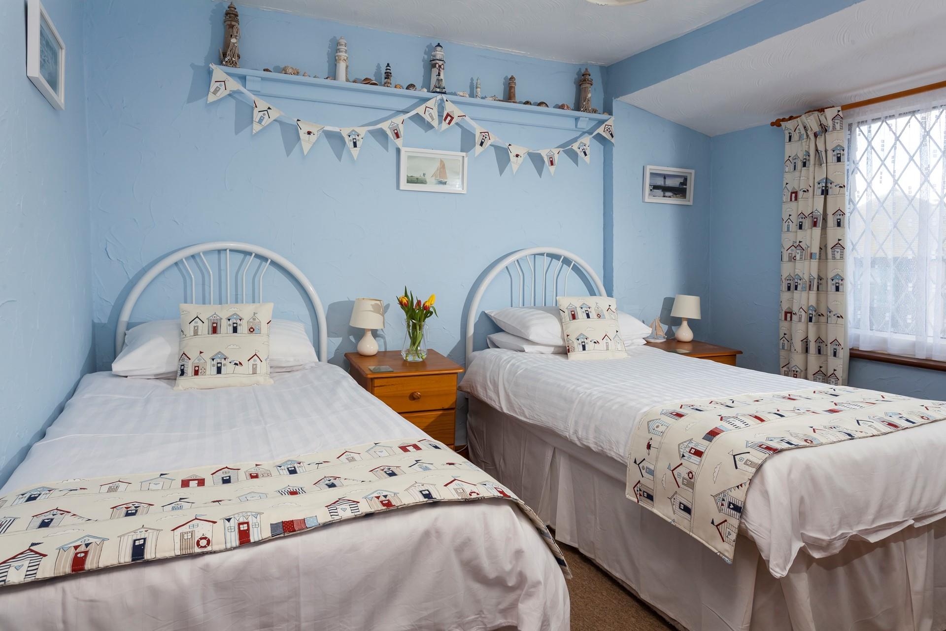 Bedroom 2 has seaside decor reflecting the cottage's close proximity to the sea.