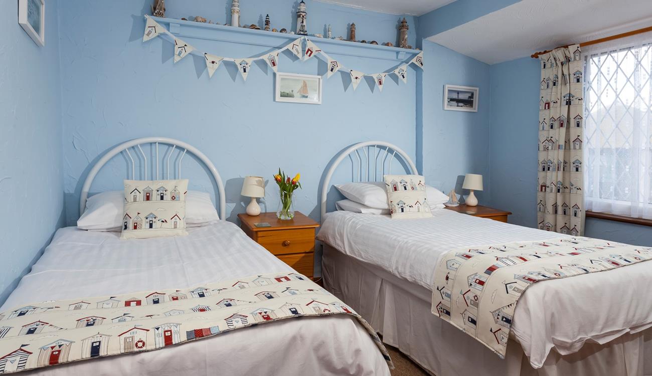Bedroom 2 has seaside decor reflecting the cottage's close proximity to the sea.