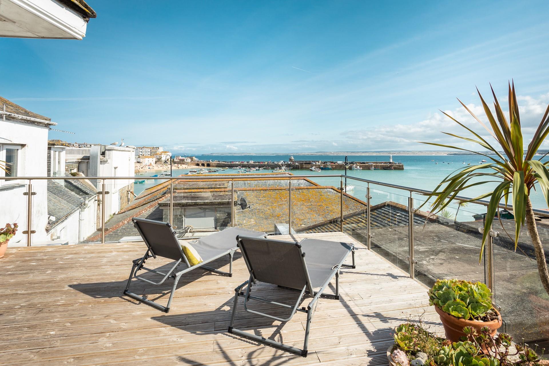 Relax on your rooftop sun lounger with a glass of something cold soaking up the sun in front of stunning views of St Ives.