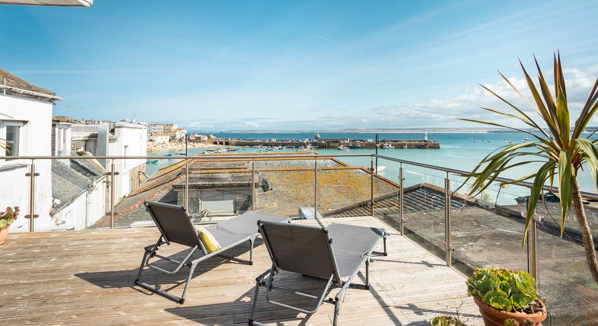 Relax on your rooftop sun lounger with a glass of something cold soaking up the sun in front of stunning views of St Ives.