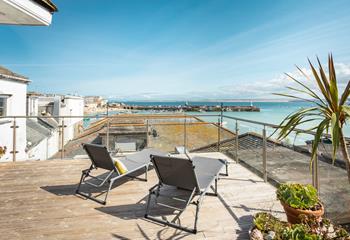 Relax on your rooftop sun lounger with a glass of something cold soaking up the sun in front of stunning views of St Ives.