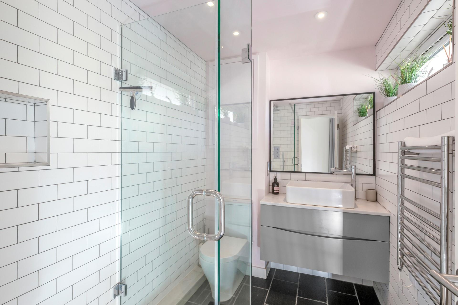 The bathroom is modern and fresh with a walk in shower.