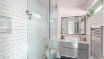 The bathroom is modern and fresh with a walk in shower.