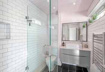 The bathroom is modern and fresh with a walk in shower.