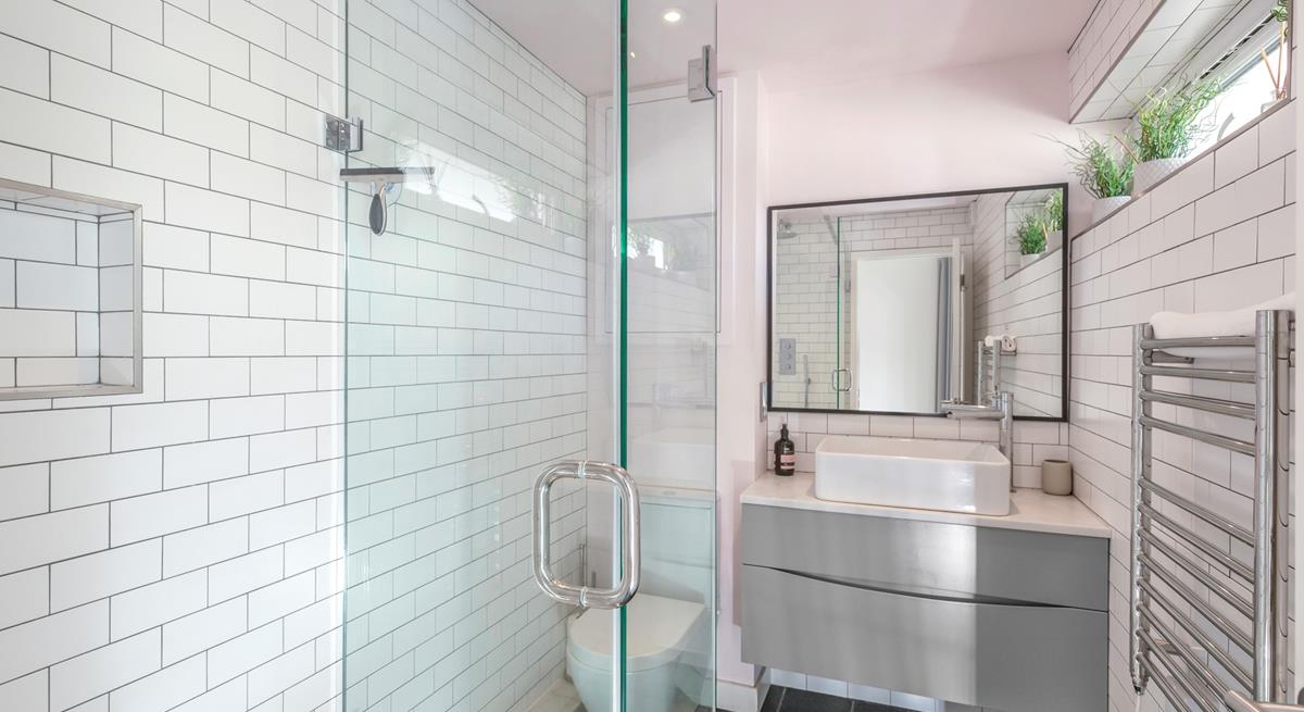 The bathroom is modern and fresh with a walk in shower.