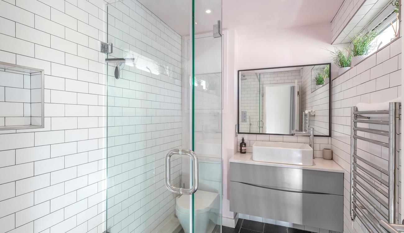 The bathroom is modern and fresh with a walk in shower.