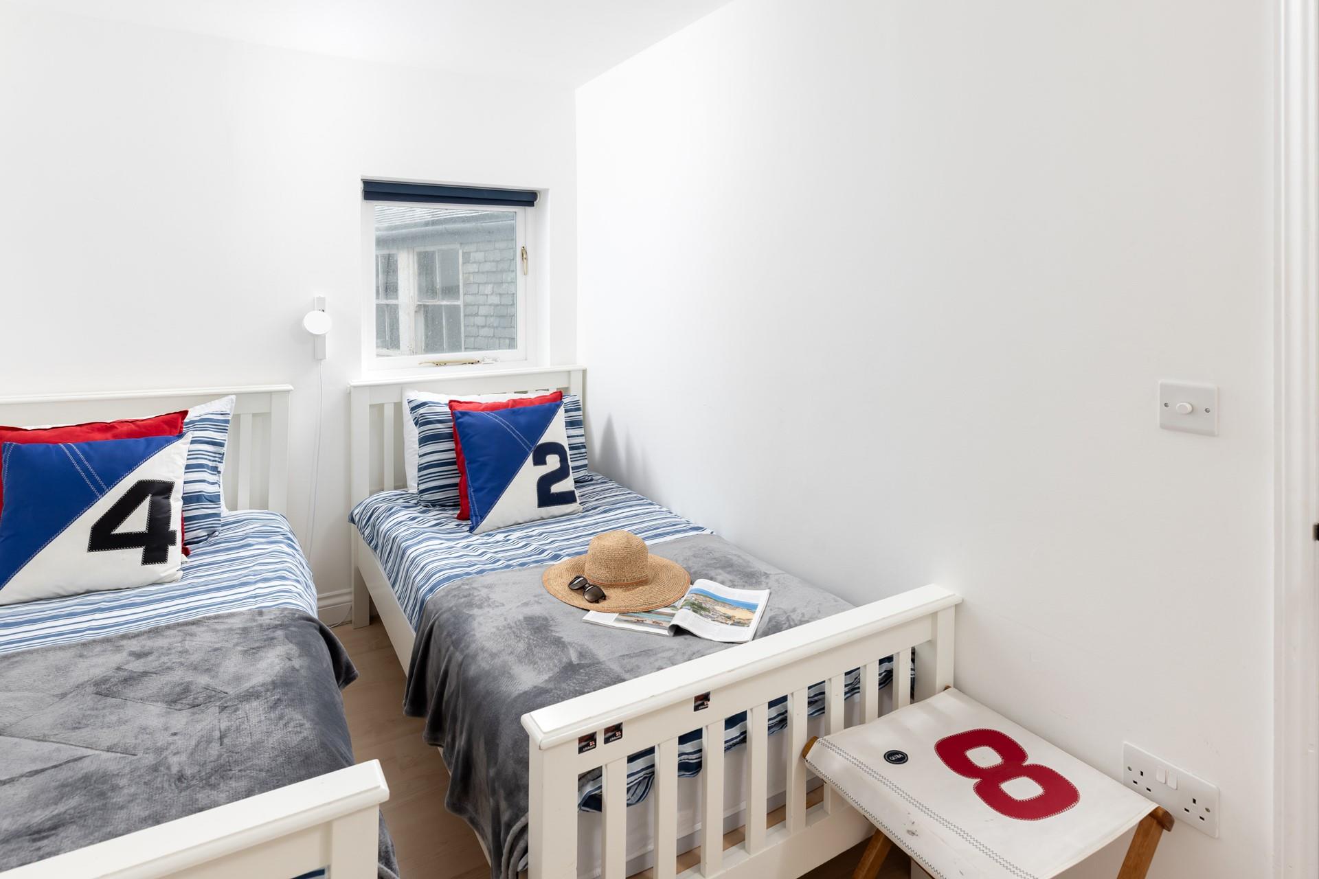 The twin bedroom continues the coastal theme, a nod to the seaside location.