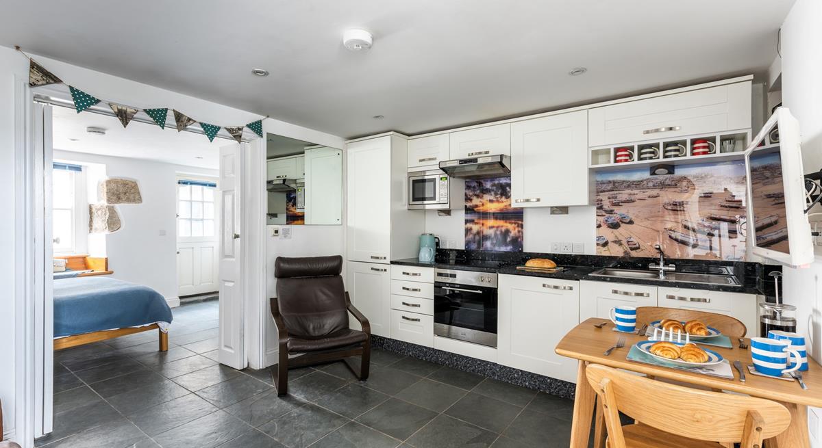The kitchen is fully equipped with modern appliances whilst iconic images of St Ives add to its charm.