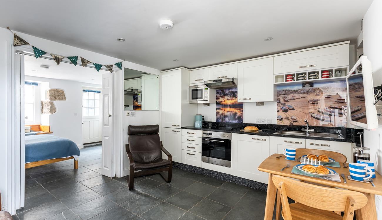 The kitchen is fully equipped with modern appliances whilst iconic images of St Ives add to its charm.