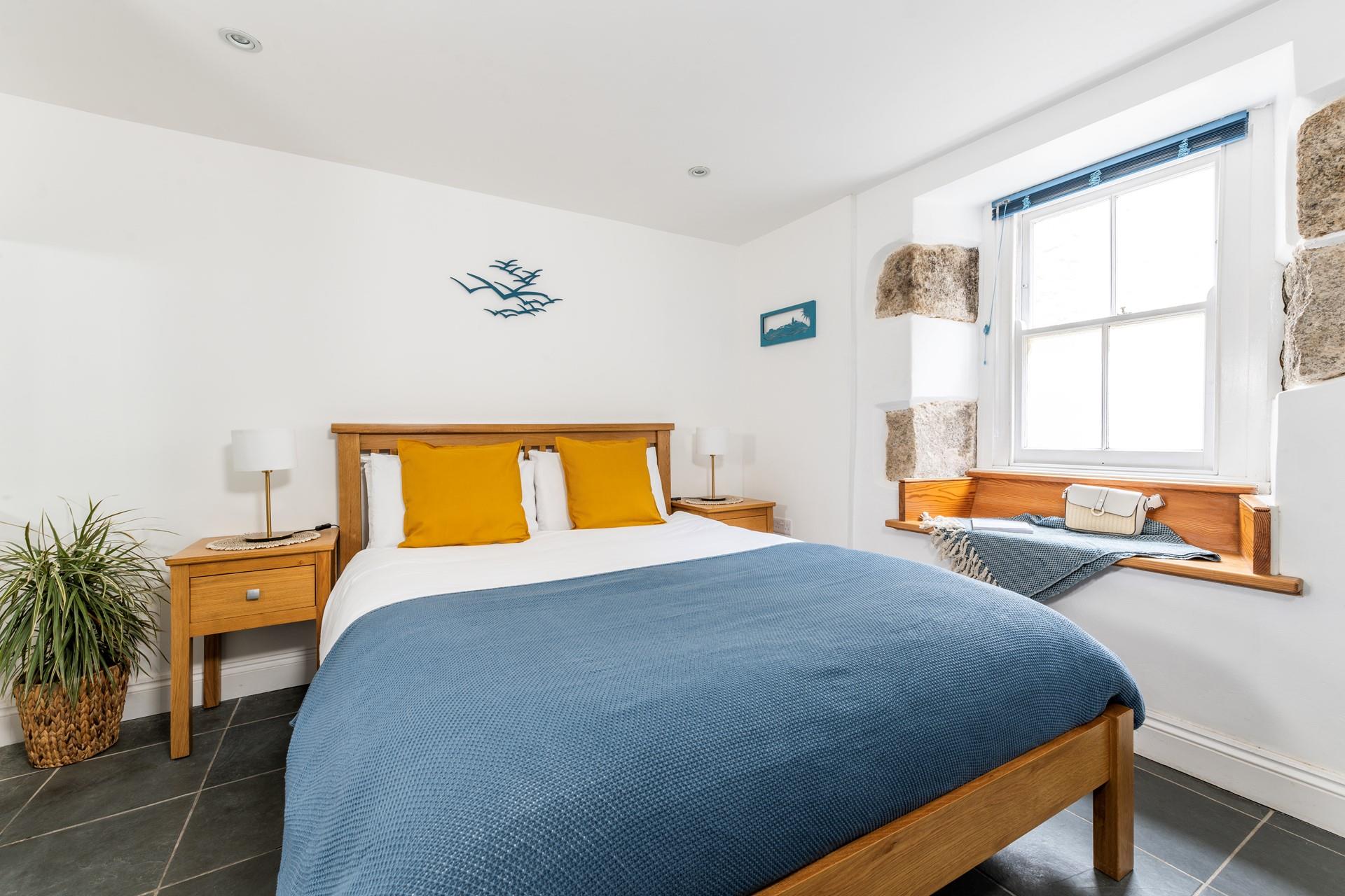 Exposed stone and classic wooden furniture give the bedroom a cute cottage feel, perfect for cosying up in.