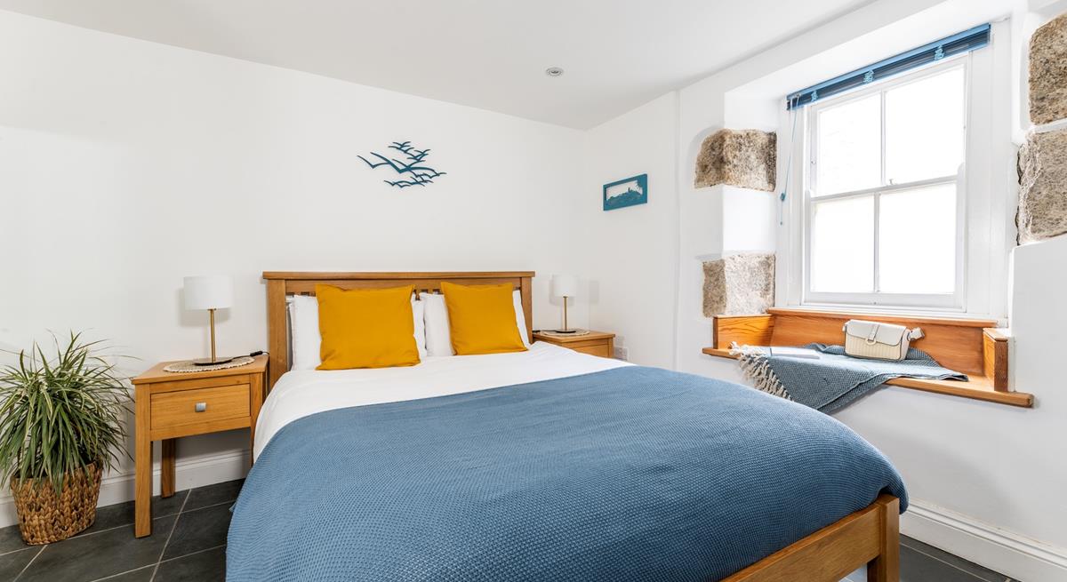 Exposed stone and classic wooden furniture give the bedroom a cute cottage feel, perfect for cosying up in.