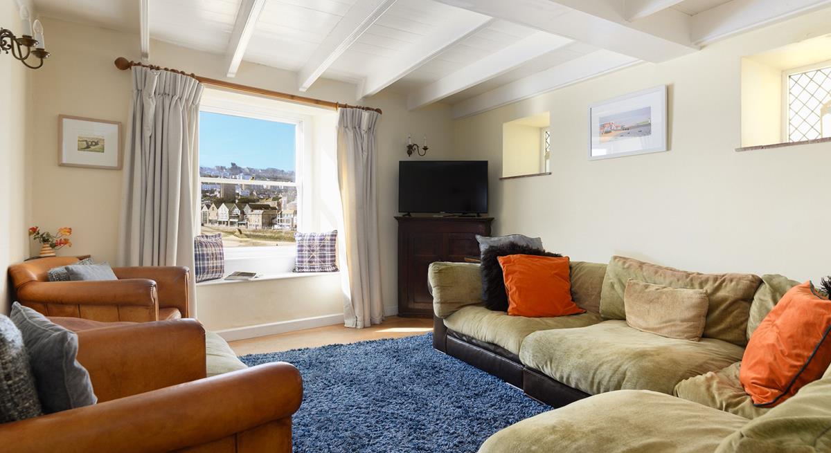 The cosy sitting room offers calming muted tones and ample seating, perfect for gathering together for a family games night.