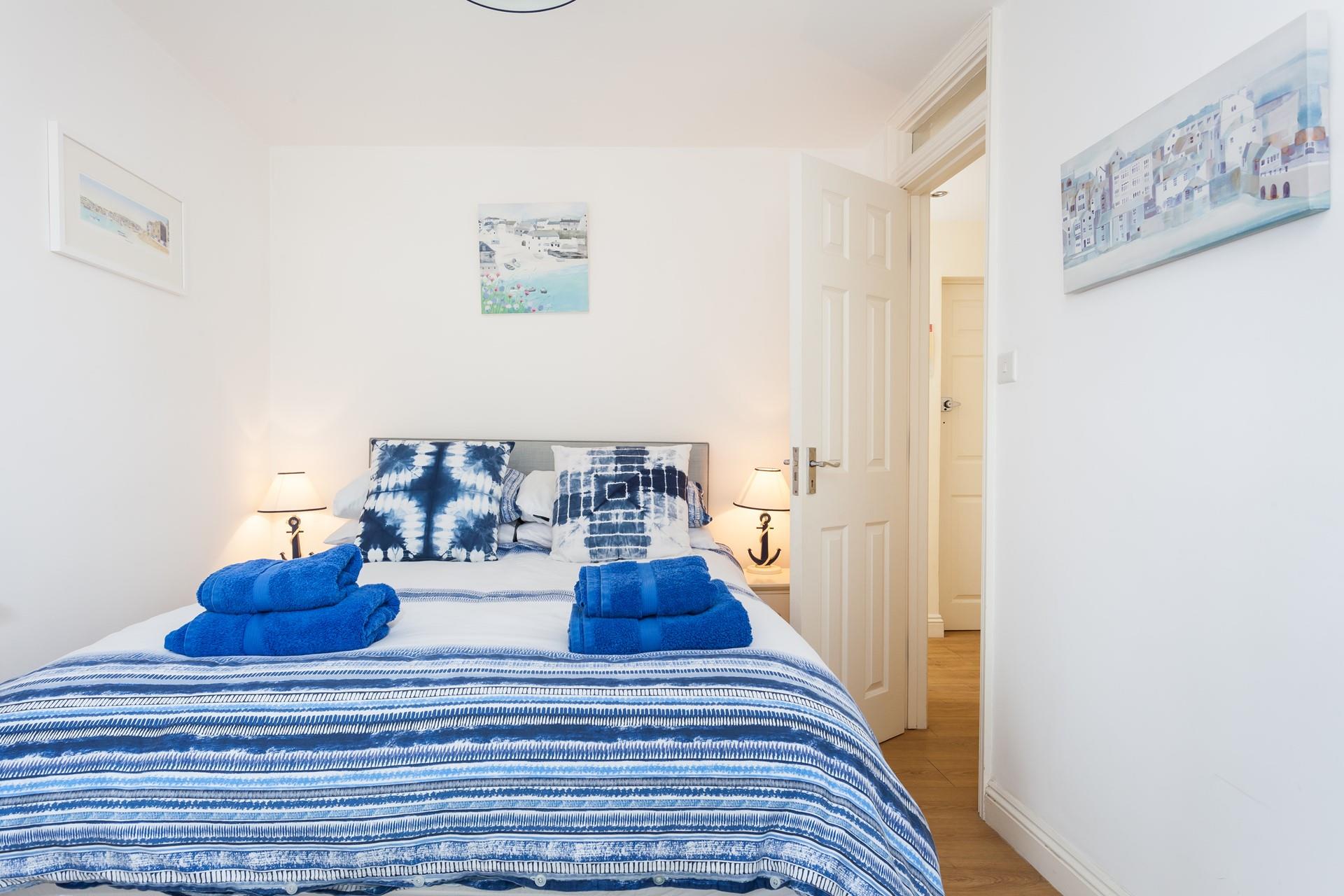 The bedroom is decorated in blue seaside tones.