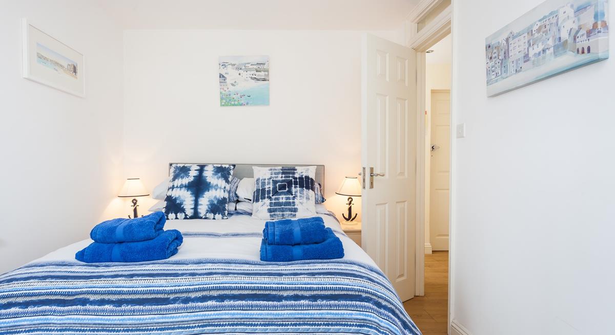 The bedroom is decorated in blue seaside tones.