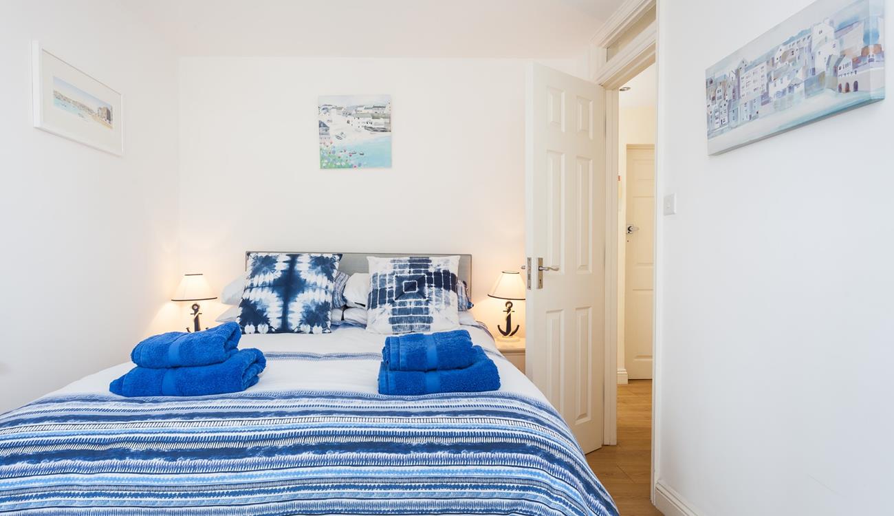 The bedroom is decorated in blue seaside tones.