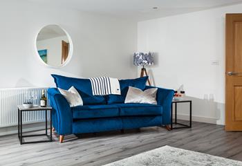 The stylish deep blue sofa makes for a sumptuous space to relax.