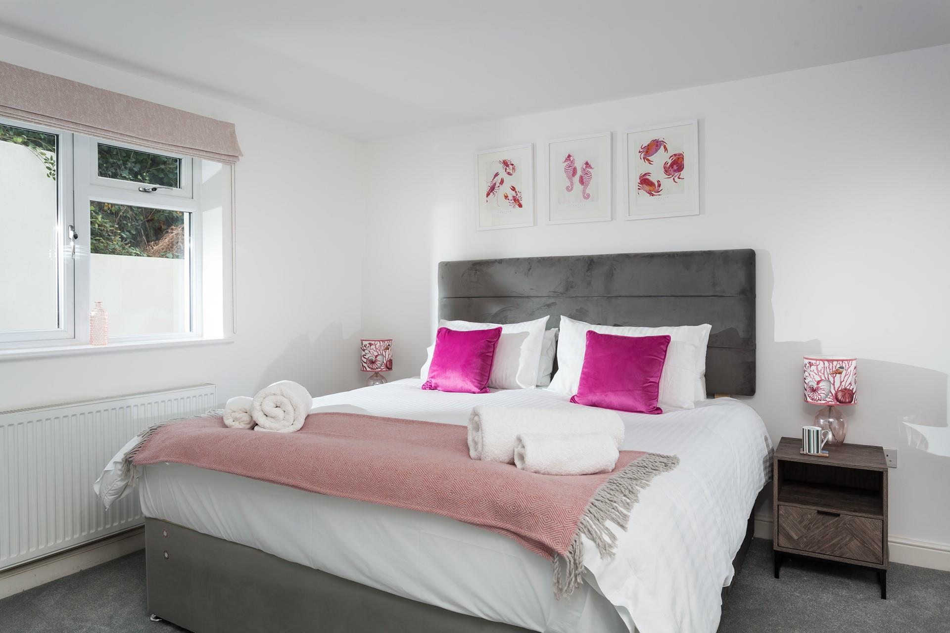 Bedroom 1 is decorated with a pop of colour and sealife artwork.