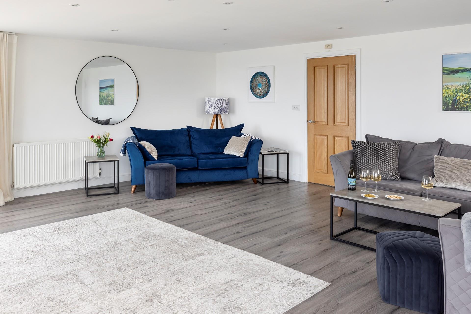 The stylish deep blue sofa makes for a sumptuous space to relax.