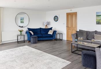 The stylish deep blue sofa makes for a sumptuous space to relax.