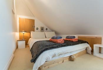 The sloping ceiling and king size bed add to this bedroom's cosy feel.