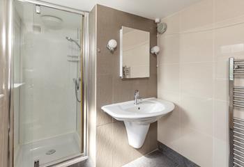The stylish bathroom has a step-in shower and a heated towel rail.