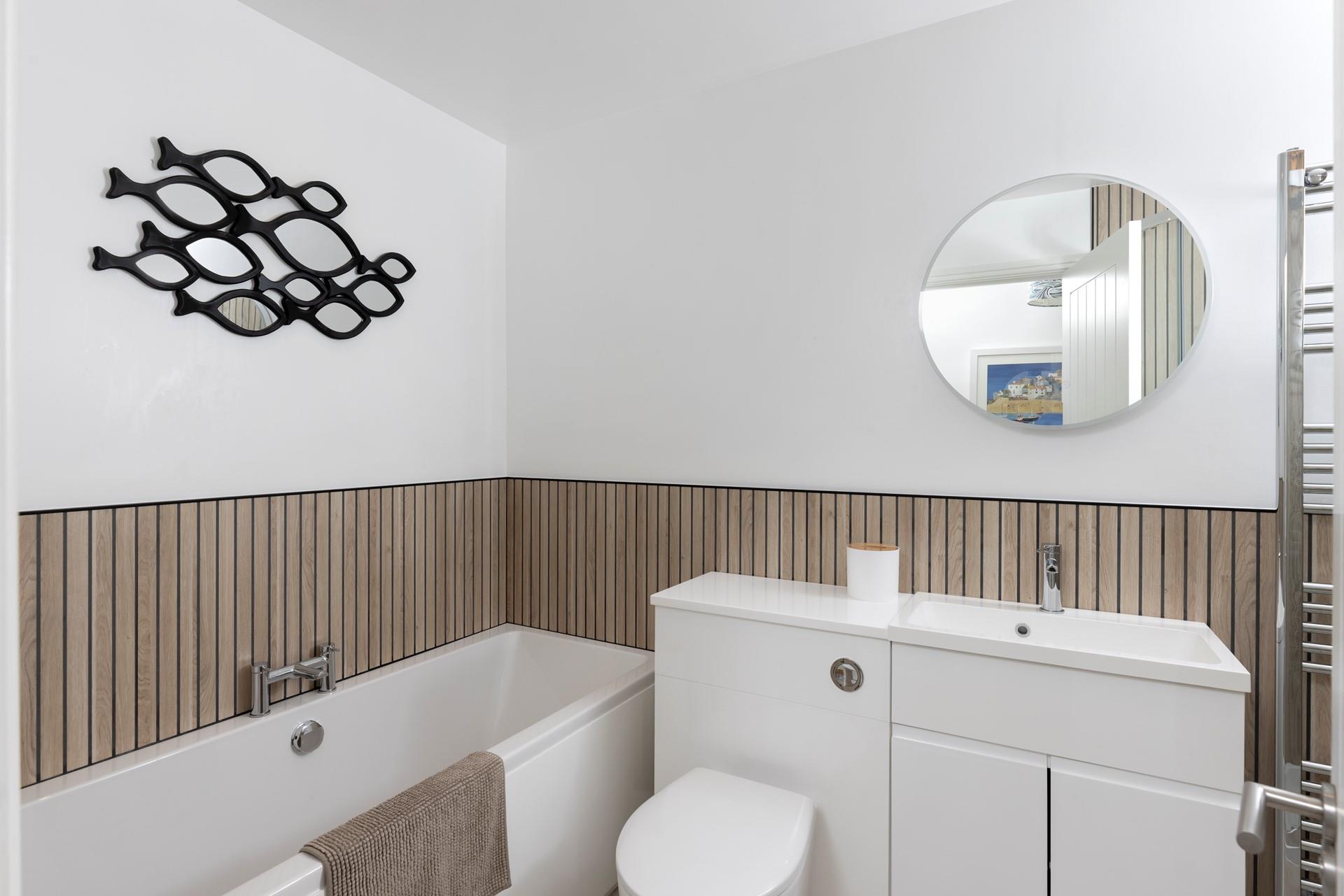 The modern bathroom offers a relaxing tub for an evening soak.