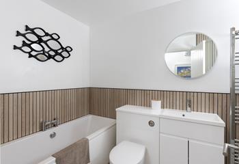 The modern bathroom offers a relaxing tub for an evening soak.