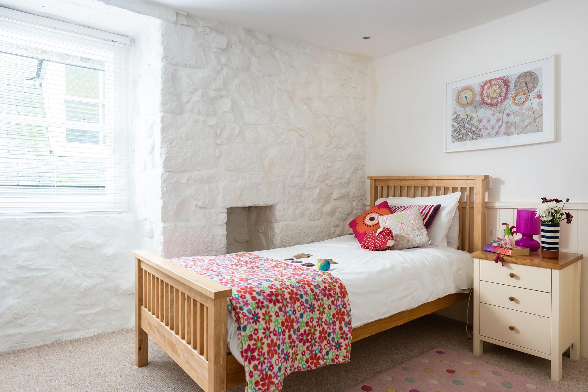 The single bedroom is bright and welcoming with quaint cottage features.