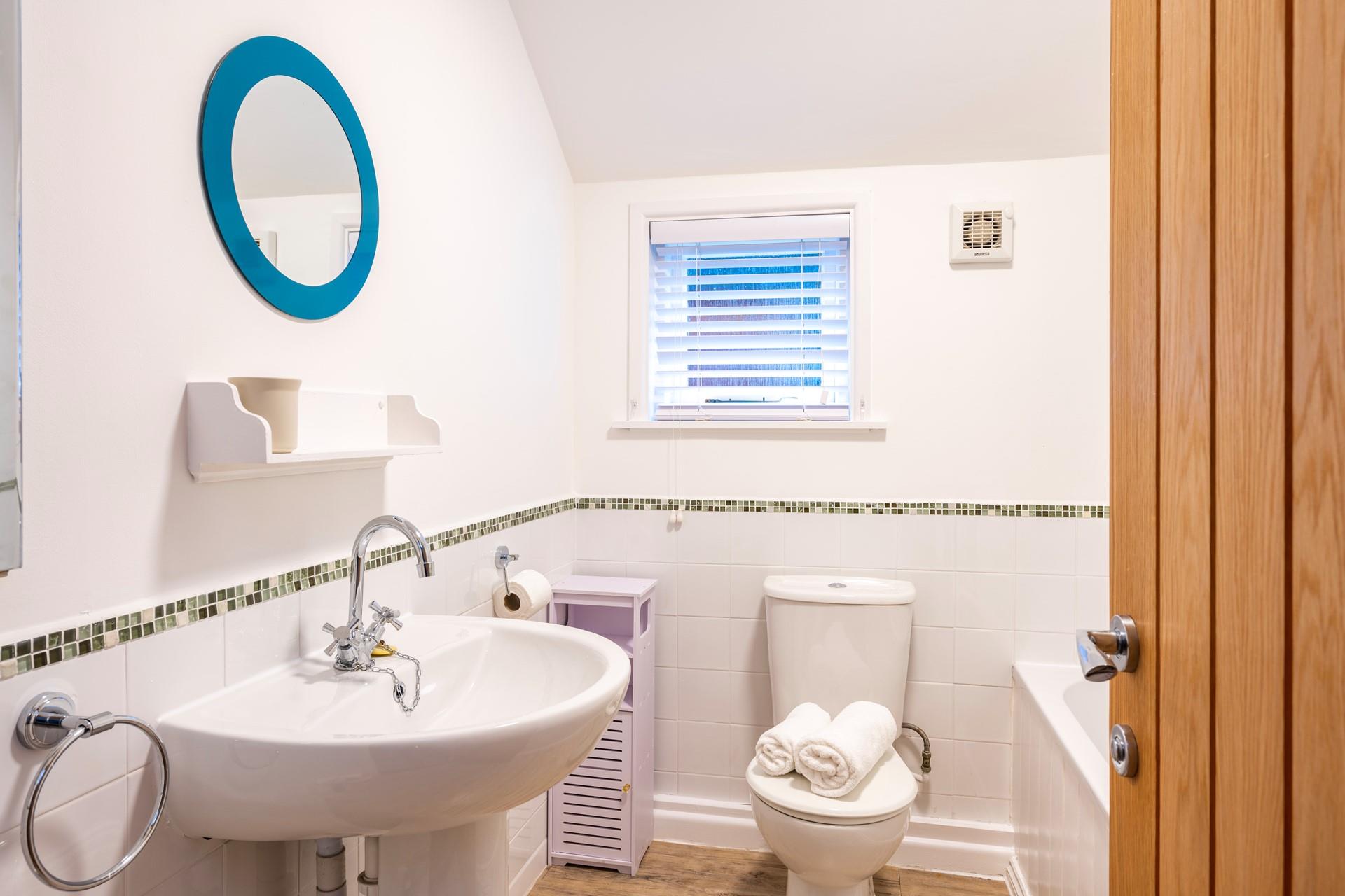 The bathroom is bright and fresh with minimalistic decor, perfect for beginning your day with an invigorating shower.