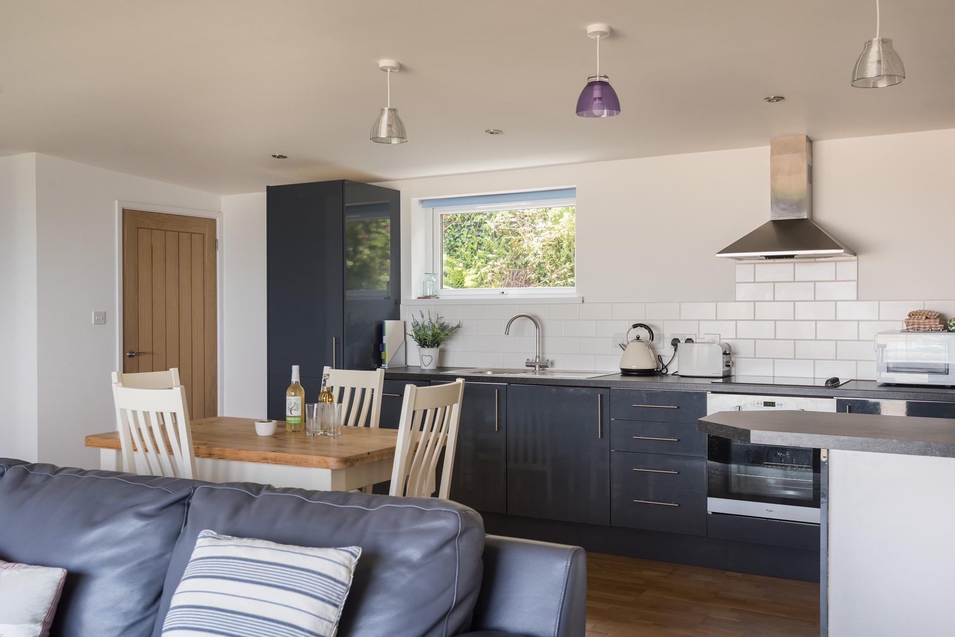 Modern and sleek, the kitchen is well-equipped and the open plan design takes advantage of those wonderful sea views. 