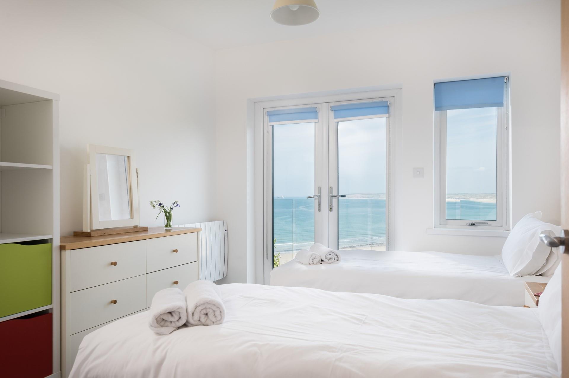 Bright and airy, the glass doors and window fill the second bedroom with natural light. At night the sunsets are divine! 