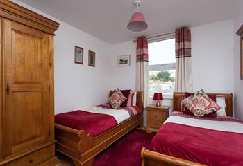 Comfortable twin bedroom with wooden furnishings and a red theme.