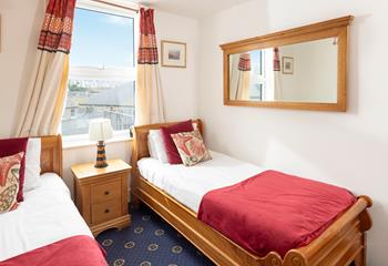 Comfortable twin bedroom with wooden furnishings and a red theme.