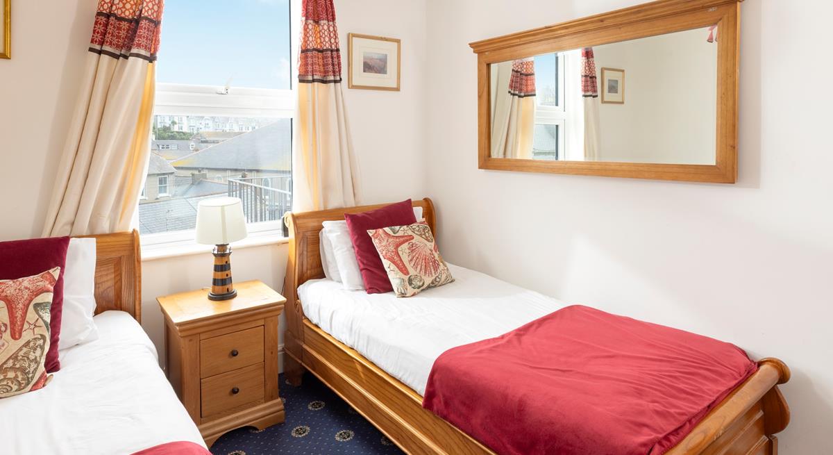 Comfortable twin bedroom with wooden furnishings and a red theme.