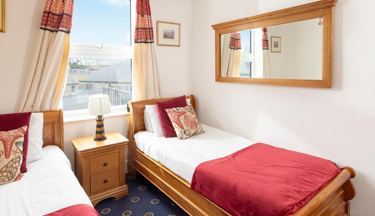 Comfortable twin bedroom with wooden furnishings and a red theme.