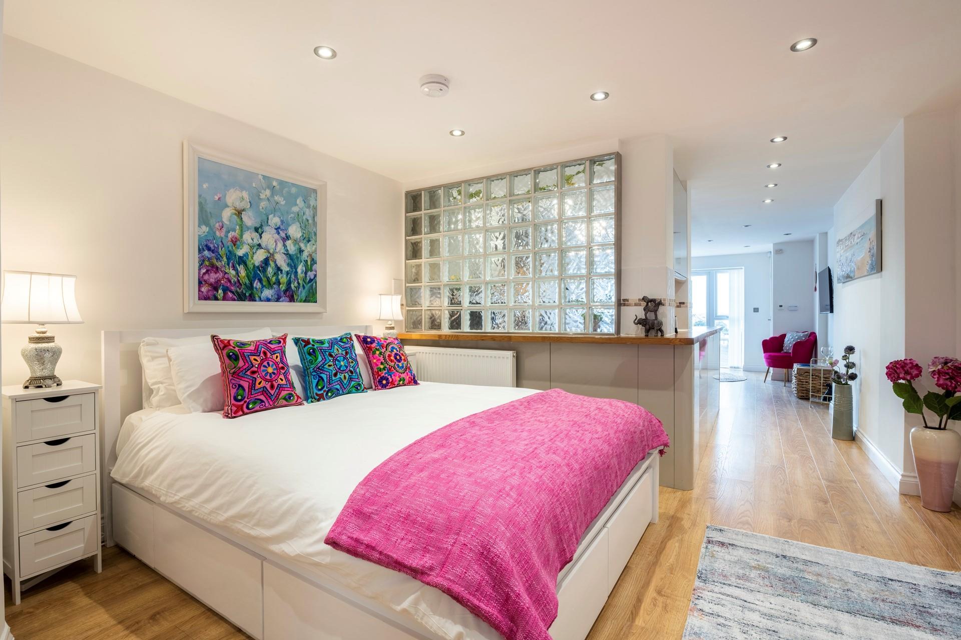 The bedroom is cleverly tucked away behind the frosted glass partition, offering privacy.