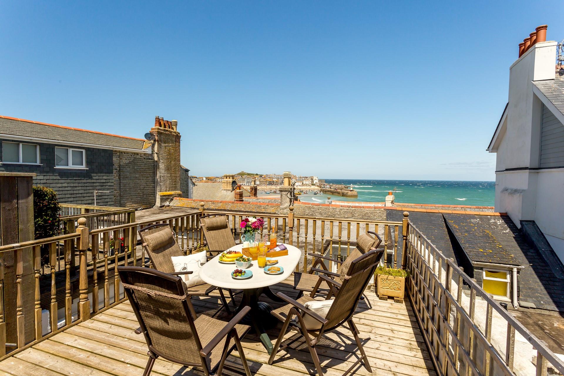 Lovely sea-view decking area at the rear of the cottage with quality patio furniture including reclining chairs.
